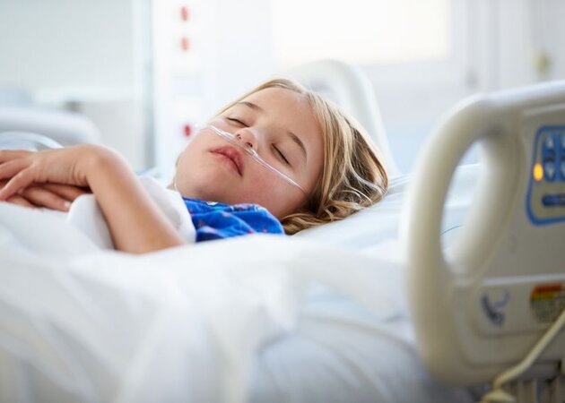 Kind schläft im Krankenbett