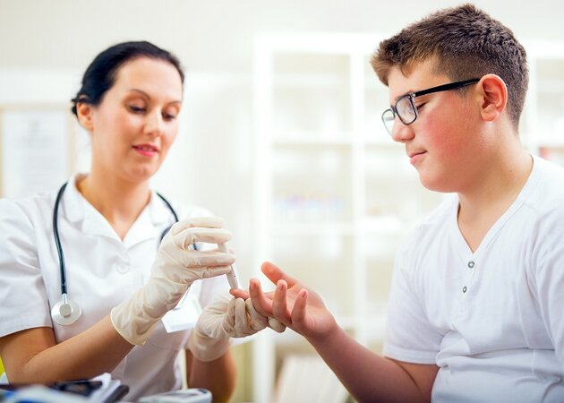 Kind und Pflegekraft bei Diabetes-Test