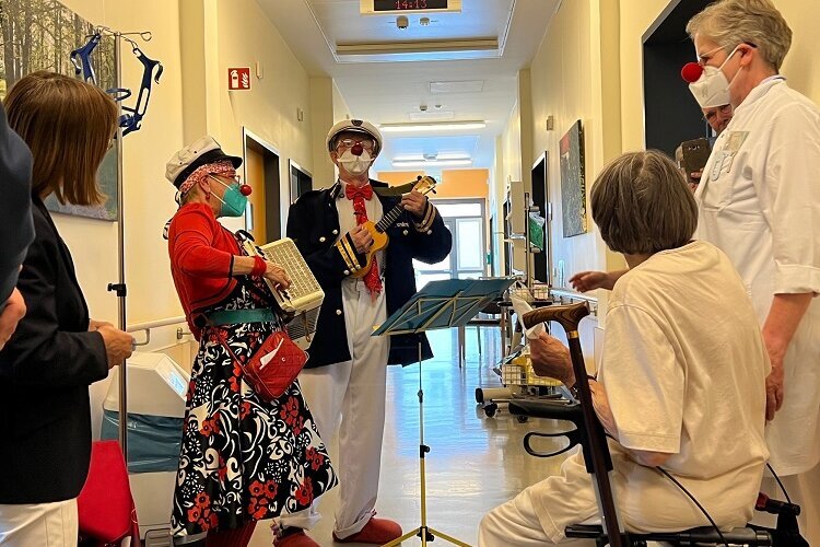 Die Clowns „Widu“ und „Béta Caténine“ spielen auf dem Gang der Klinik für Geriatrie ein Ständchen für die Patient*innen und die Gesundheitsministerin Nonnemacher.